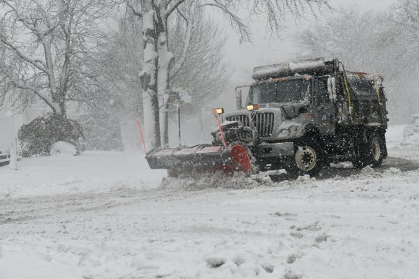Crews in Southampton Village work to clear roads as a steady snow falls on Tuesday morning.  DANA SHAW