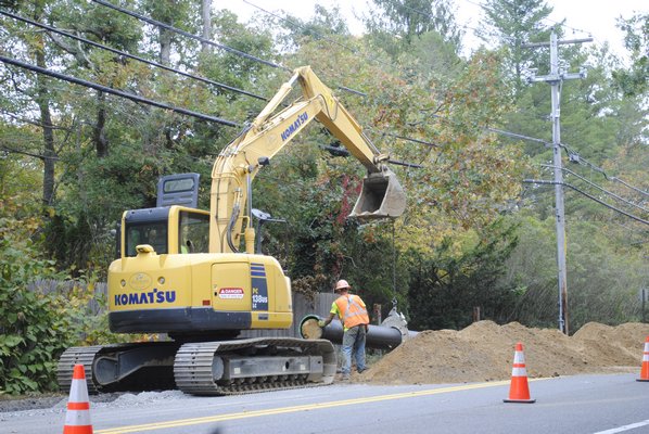 An exavator installs a pipe for a water main project on Montauk Highway in Quogue. AMANDA BERNOCCO