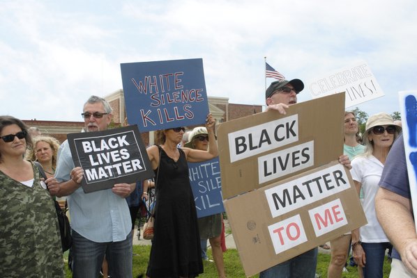 Participants hold signs during a Black Lives Matter rally in Westhampton Beach on Sunday. AMANDA BERNOCCO