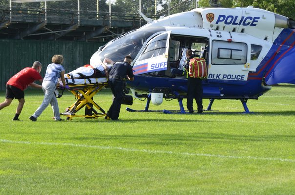 A person is loaded into a Suffolk County Police medevac helicopter at the Westhampton Beach High School following a two-car crash on Old Riverhead Road on Thursday afternoon. BY ERIN MCKINLEY