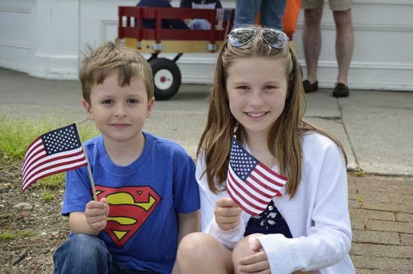 Sofia and Robert Elder wave American flags during the Memorial Day Parade in Southampton VIllage on Monday. BY ERIN MCKINLEY