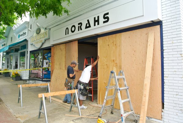 A crew works to board up Norahs on Jobs Lane on Thursday after an SUV crashed into the front of the store on Wednesday evening. BY DANA SHAW