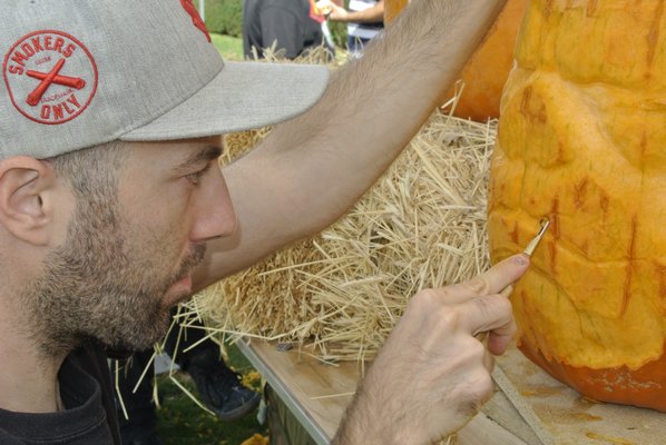 Mark Evan of the Maniac Pumpkin Carvers works on a Gammorean Guard pumpkin.