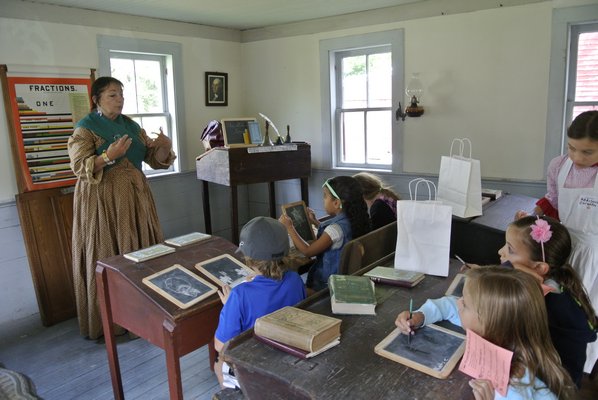 Kids get a lesson at the schoolhouse on the 