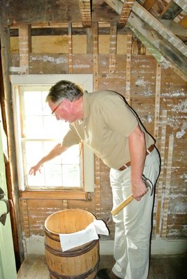 Tom Edmonds with demonstrates problems with the windows at the Halsey House. DANA SHAW