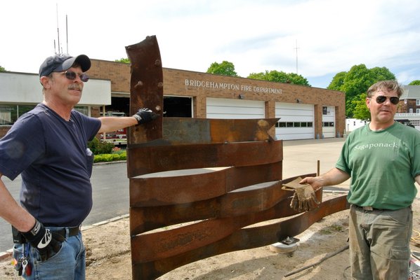 Dean Foster and Ray Topping Jr. work to put the memorial in place on Wednesday