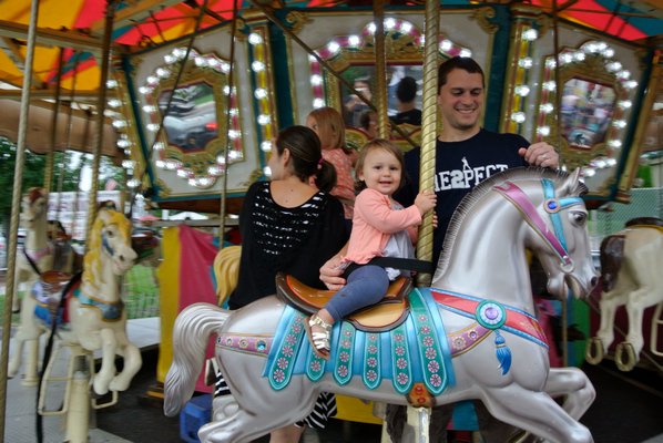 Stella Kropfl rides the carousel at the Hampton Bays Fire Department Carnival on Sunday.