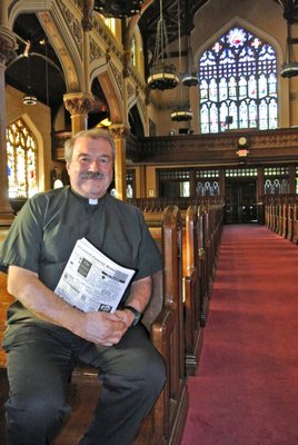 Father Mike Vetrano sits in the pews that are to be refinished as part of the In Nomine Domini Fund at the Basilica of the Sacred Hearts of Jesus and Mary.  DANA SHAW