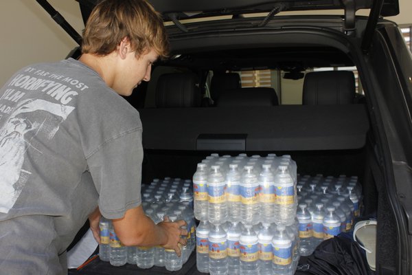 Adam Jannetti loading his car with cases of Hamptons Fresh water. VALERIE GORDON 