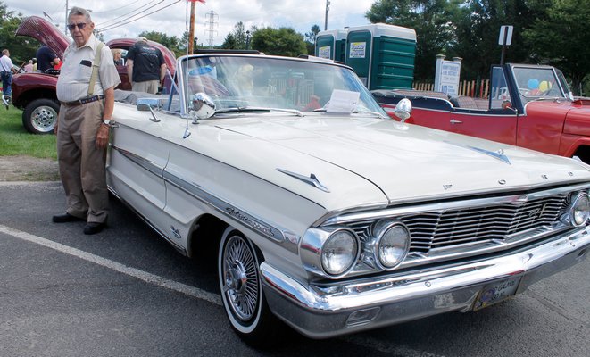 Hampton Bays resident Pete Penny stands with his 1964 Ford Galaxy during the Hampton Bays Fire Department Car Show on Saturday afternoon. KYLE CAMPBELL
