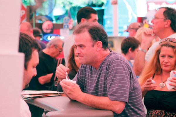 Hampton Bays resident Mike Dunn enjoys a sample of the Scotto's Pork Store during the 16th annual Hampton Bays Chamber of Commerce Chili/Chowder Contest on Sunday afternoon at the Boardy Barn in Hampton Bays. KYLE CAMPBELL
