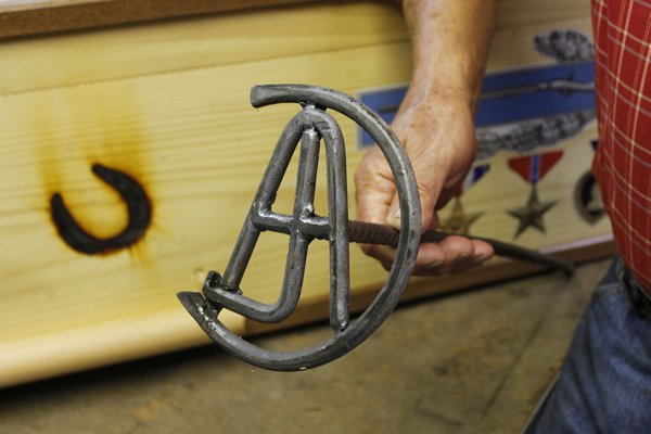 A handcraft brand made by East Quogue resident Ron Campsey bearing his father's initials. Mr. Capsey used the brand to decorate the casket he built for his dying father last month. KYLE CAMPBELL