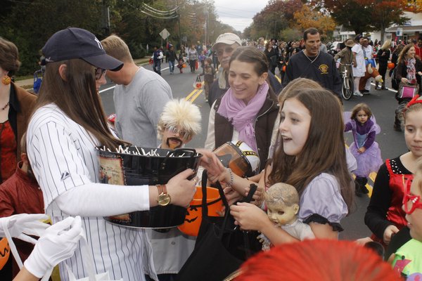 Children rush to collect candy along Mill Road during the Westhampton Beach Halloween parade Friday afternoon. KYLE CAMPBELL