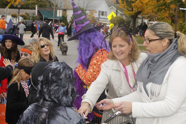 Westhampton Beach Mayor Maria Moore hands out candy in front of Village Hall on Friday afternoon during the village's annual Halloween parade. KYLE CAMPBELL