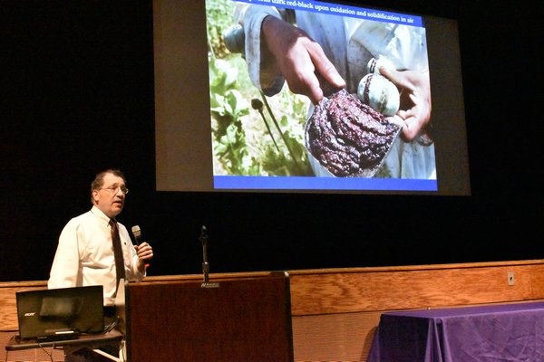 Chief Medical Examiner Michael Caplan shows a photo of the inside of a poppy plant