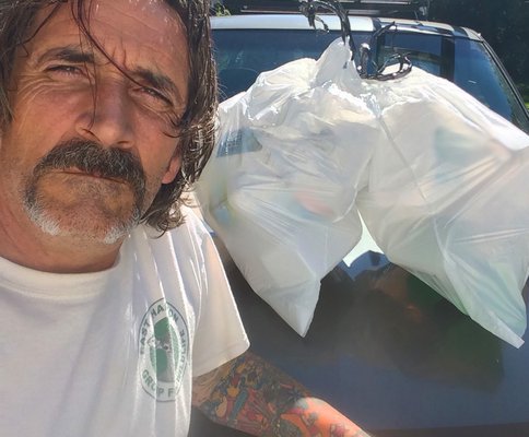 Dell Cullum with two bags of trash he picked up at Atlantic Avenue beach last weekend. DELL CULLUM
