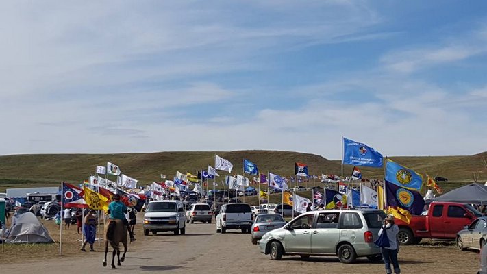 Flags of different tribes fly at Standing Rock. COURTESY LANCE GUMBS