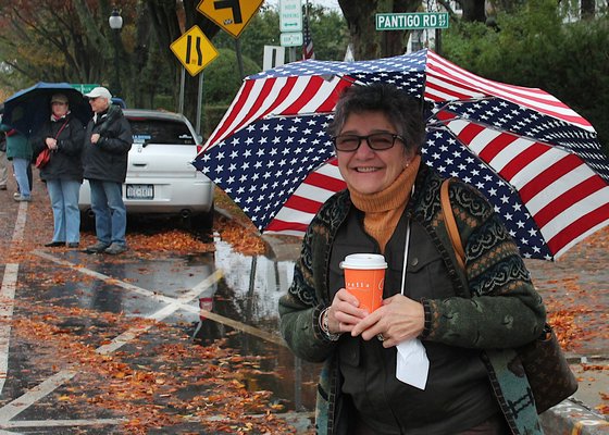 Carole Campolo keeps dry under an umbrella while watching the parade. KYRIL BROMLEY