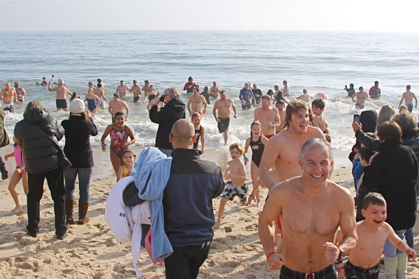 Participants linger in the surf during the Polar Bear Plunge on Main Beach in East Hampton. COURTESY MIKE BOTTINI