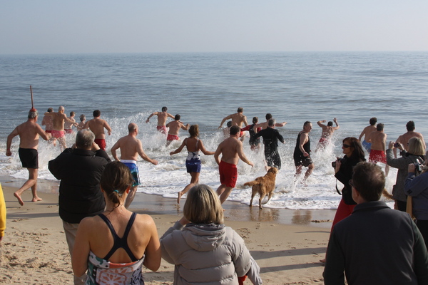 Participants linger in the surf during the Polar Bear Plunge on Main Beach in East Hampton. COURTESY MIKE BOTTINI