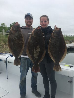 Mike and Krisztina Madr of Flanders with a brace of big fluke they caught over the weekend in the Peconics. 
