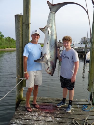 Dr. John Brennan with his son Aidan and the 103 pound thresher shark they weighed in at Molnar's Landing.  