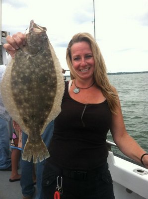 Christine Konrad of Hampton Bays shows of a fluke caught in Shinnecock Bay recently aboard the Shinnecock Star. Deena Lippman
