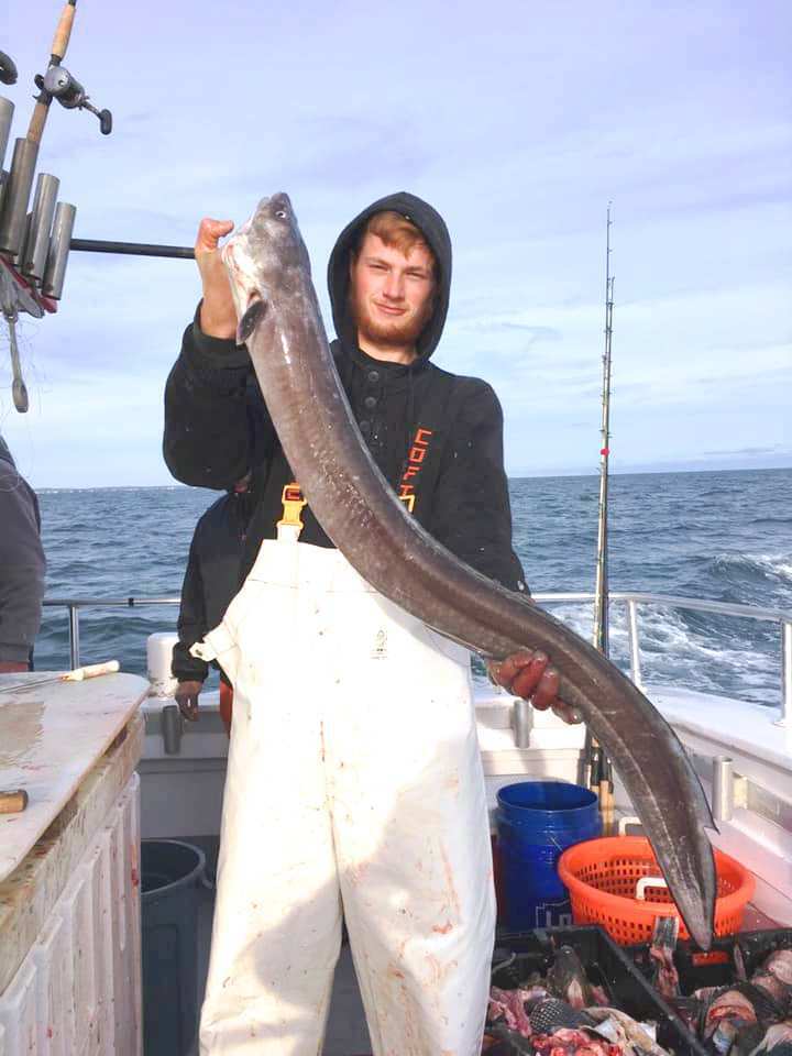 Billy Longnecker of Southampton, a mate on the Hampton Lady party fishing boat, shows off a big conger eel caught during a recent wreck fishing trip. 