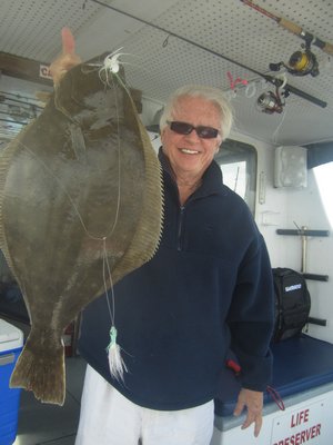 Jim Rhodes of East Quogue shows of a nice fluke caught aboard the Shinnecock Star off Hampton Bays. Deena Lippman