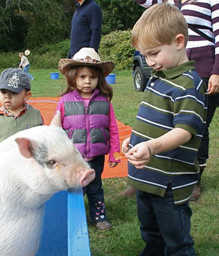 The East  Hampton food pantry held a Family Western Fair fund-raiser on Saturday at the American Legion in Amagansett. Zach Stranzer fed a pig while Salome Galindo looked on.
