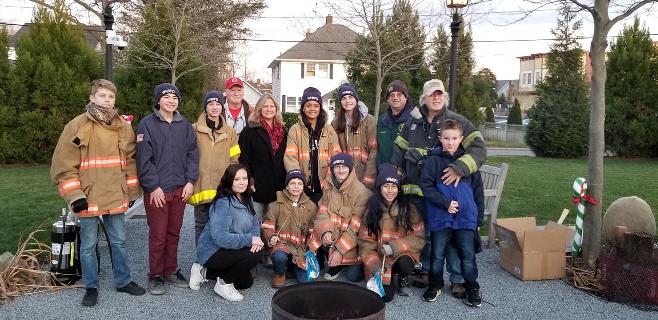 The Westhampton Beach Fire Department Juniors helped out at the Winter Festival on Saturday, December 7 by assisting young children with roasting marshmallows over an open fire and other activities. From left, Eoughan Hayward, Connor Puch, Carter Padavan, Steve Frano, Village Mayor Maria Moore, Zoe Stokes, Makayla Messina, Advisor Chris Kampher, Advisor Paul Hoyle, Evan Hoyle, Natalie Runowski, Finnegan Hayward, Jayson Kampher and Michelle Castro. 