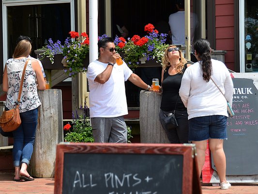 Customers enjoying a glass of beer from the Montauk Brewing Company. KYRIL BROMLEY
