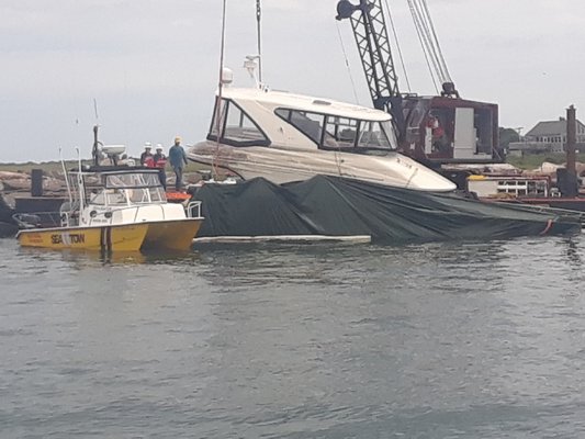 Crews from SeaTow and Costello Marina hoisted the 44-foot cabin cruiser off the bottom of Block Island Sound on Sunday.