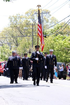 Betty Bradnick waves a few flags at the East Quogue Fire Department's annual Memorial Day parade on Sunday