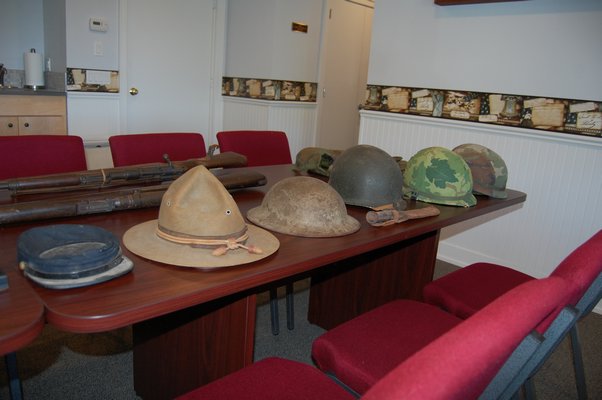 A line of military hats worn by soldiers from the Civil War up to the Gulf War. JON WINKLER