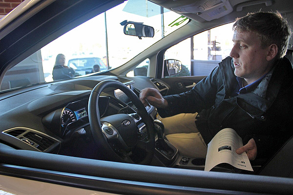 Tommy Otis shows off the new charging station for electric vehicles at Otis Ford in Quogue. CAORL MORAN