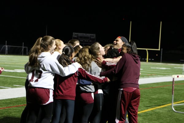The Southampton girls track team and head coach Eddie Arnold celebrate after wrapping up the program's first league title since 1977 with a win over Stony Brook on Monday. SUBMITTED PHOTO