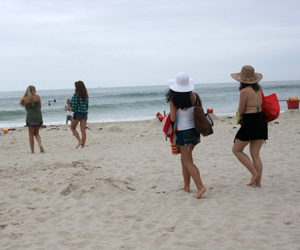 Extras walk onto Rogers Beach to film an online game for USA Network's Royal Pains