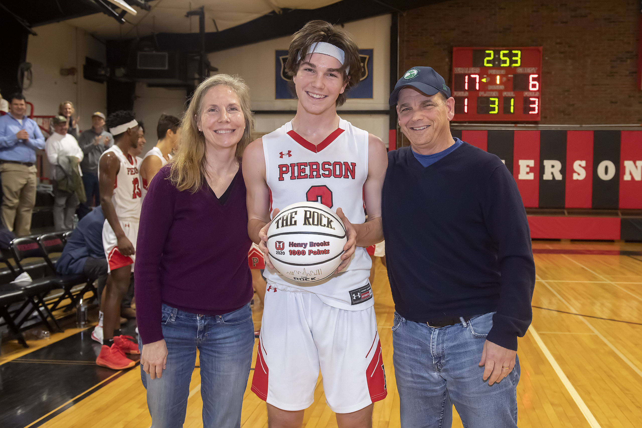 Pierson's Henry Brooks with his parents, Margaret and Scott, after he made his 1,000th career point on Monday night.