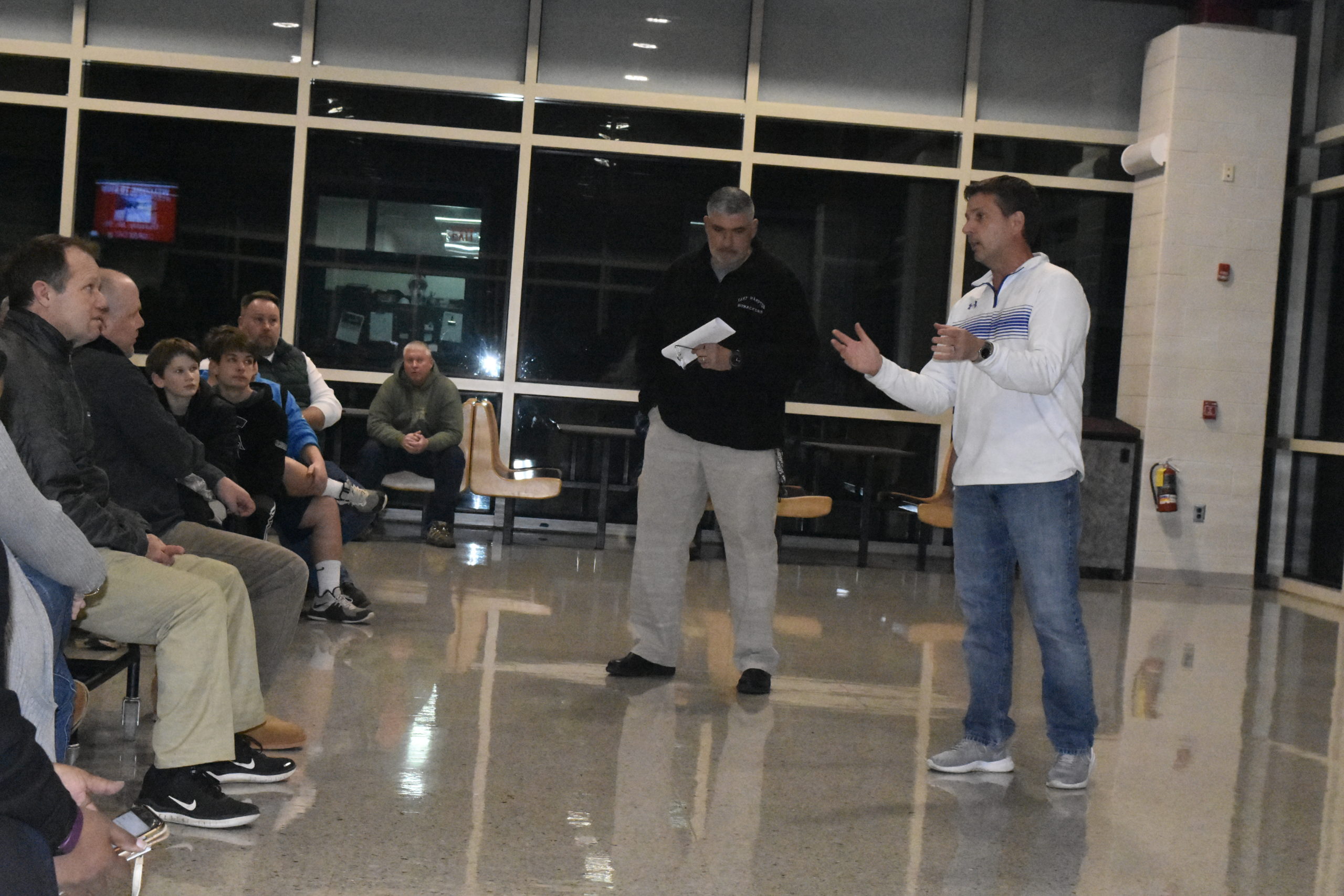 East Hampton Athletic Director Joe Vasile-Cozzo, left, and Southampton Athletic Director Darren Phillips talk with parents and players during a football meeting on Thursday, January 9.