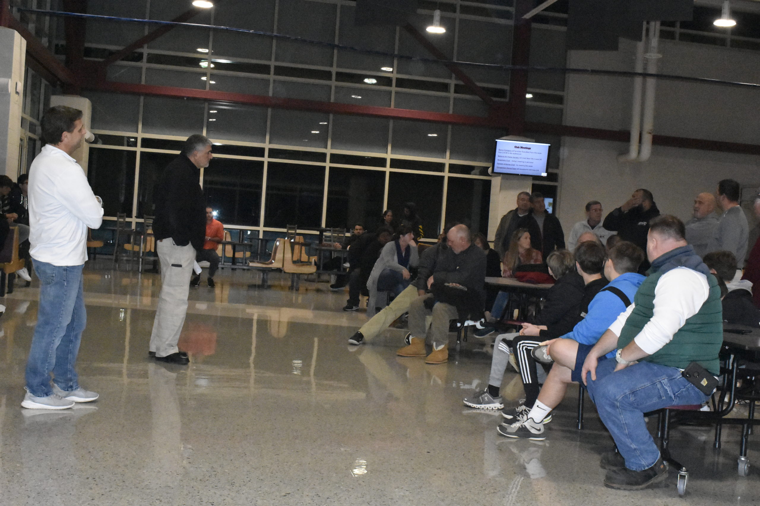 East Hampton Athletic Director Joe Vasile-Cozzo and Southampton Athletic Director Darren Phillips talk with parents and players during a football meeting on Thursday, January 9.