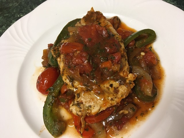 Plated chicken breasts with peppers and tomatoes. 