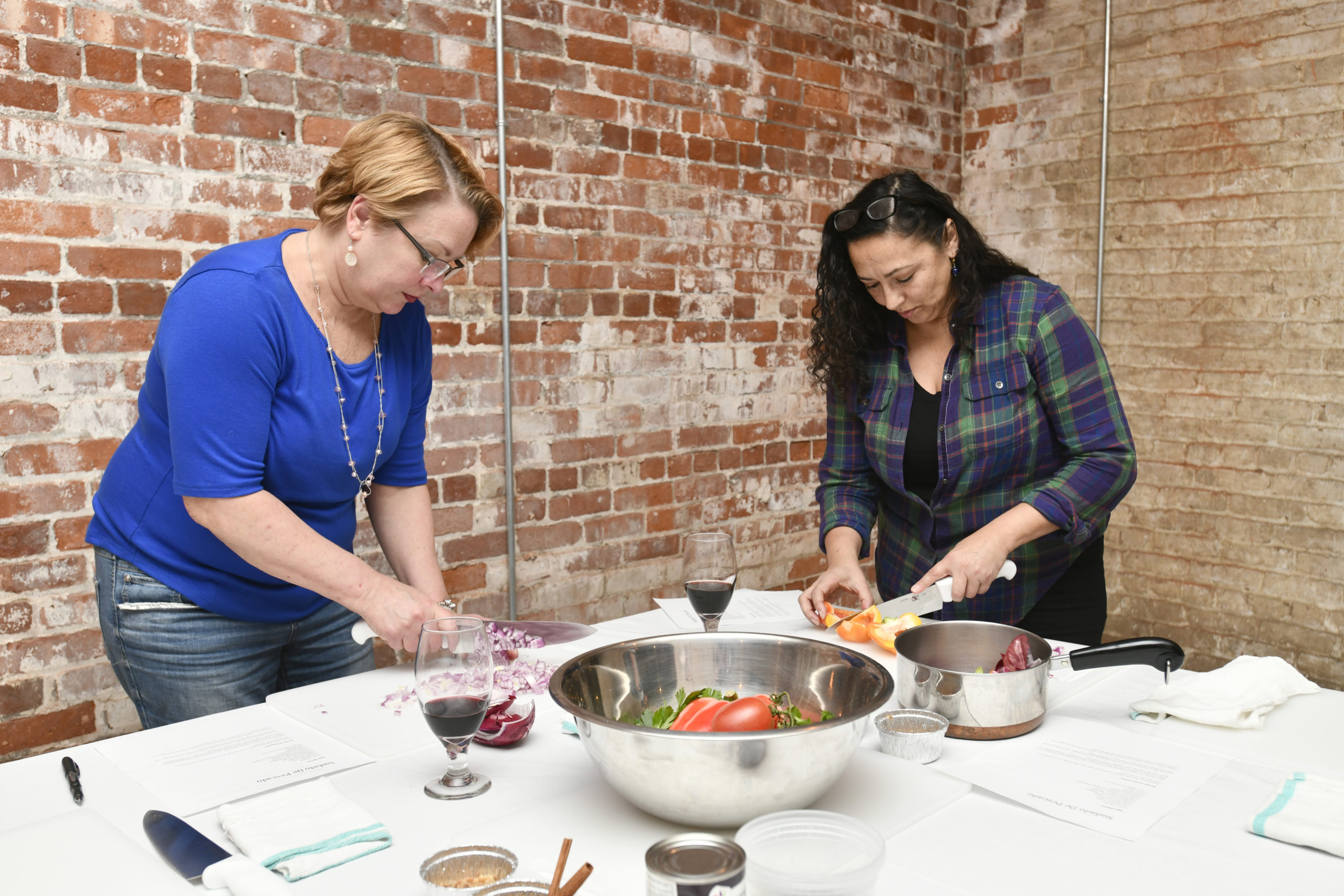 Students Lisa Westfall and Marilyn Cruz chop vegetables.
