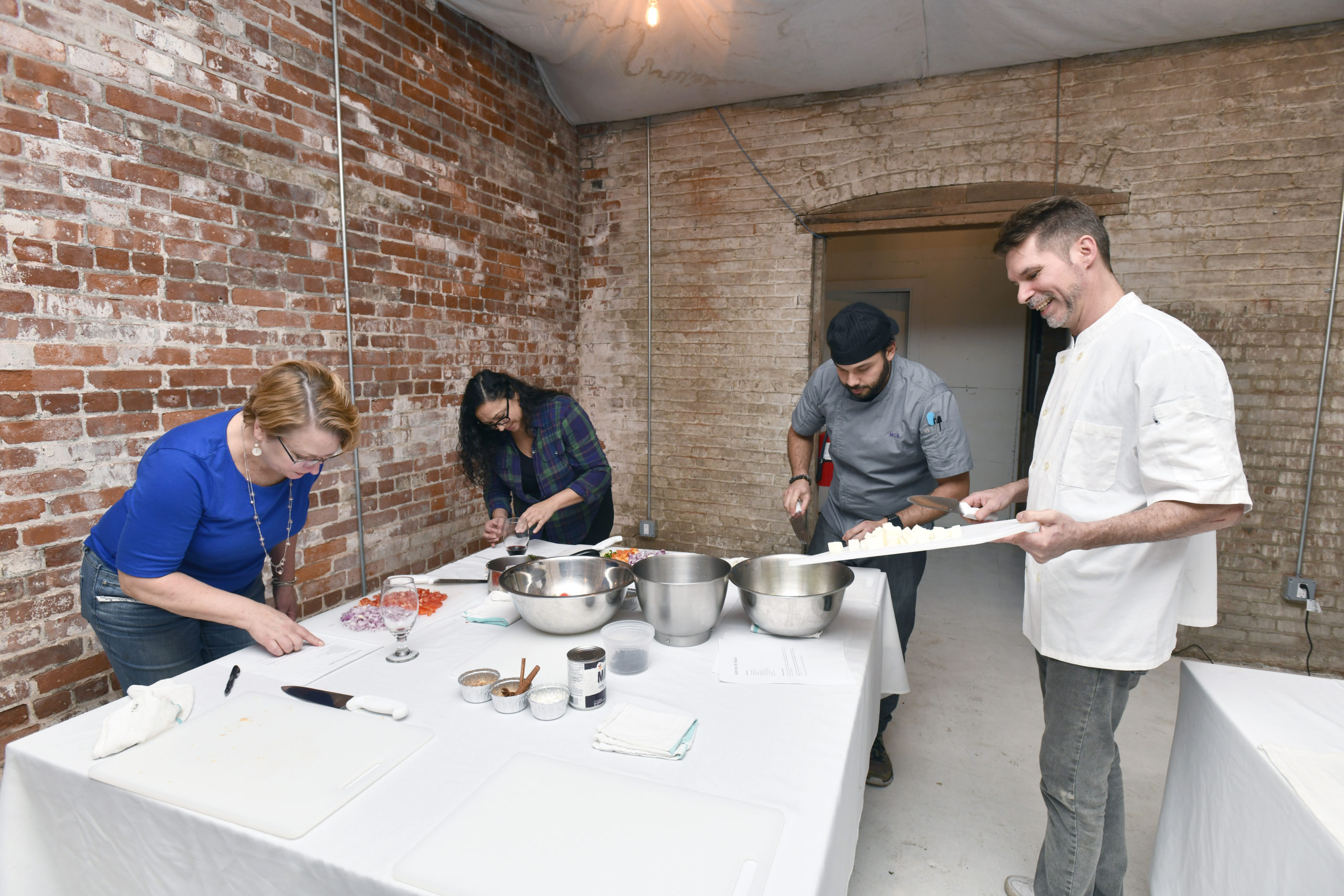 Chefs Nicolas Reisini and Jon Albrecht work with students Lisa Westfall and Marilyn Cruz.