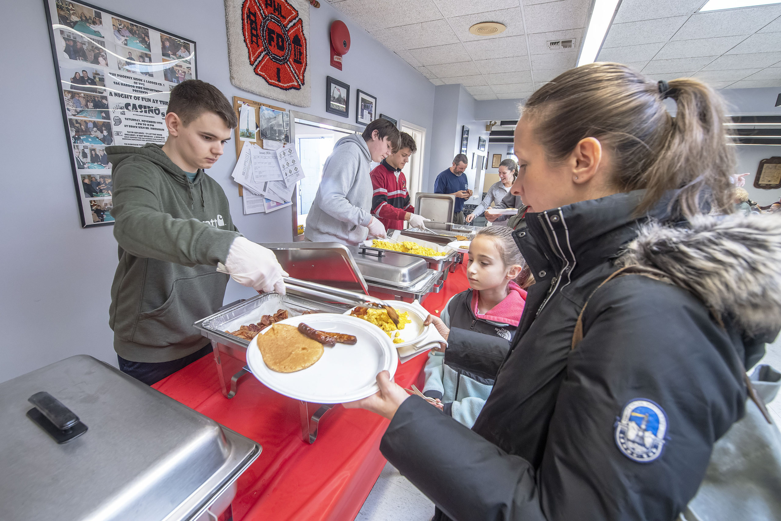 J.J. Murray serves up hash browns as his pals Colby Wilson and Truman Yardley handle the pancakes, eggs, sausage and bacon duities during the Pancake Breakfast held to benefit the Pierson Robotics Team at the Sag Harbor Fire Department firehouse on Sunday.   MICHAEL HELLER