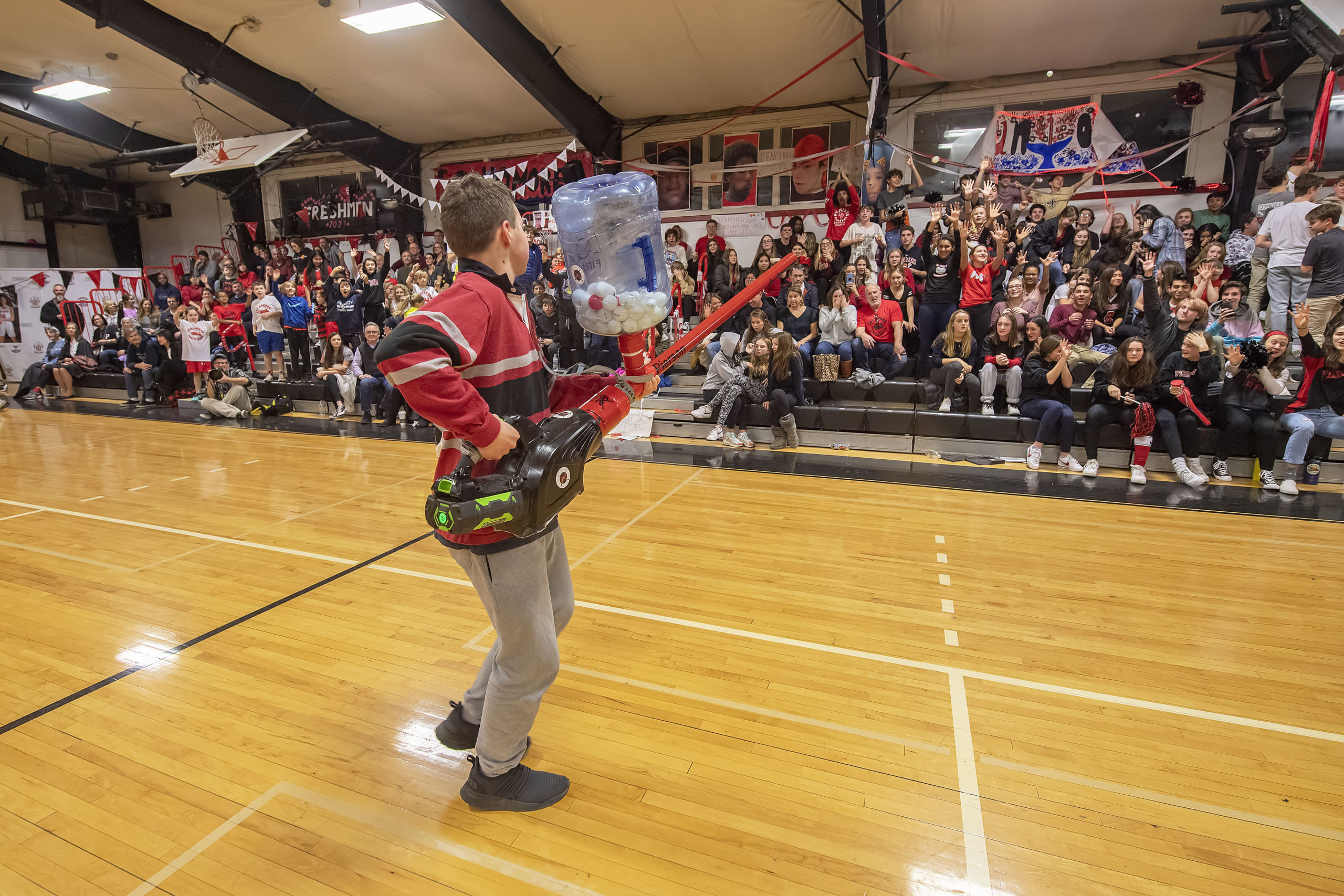 A member of the Pierson Robotics Team shoots ping pong balls into the crowd during a halftime demonstration as part of the 2020 Spirit Night festivities at Pierson High School on Friday night.