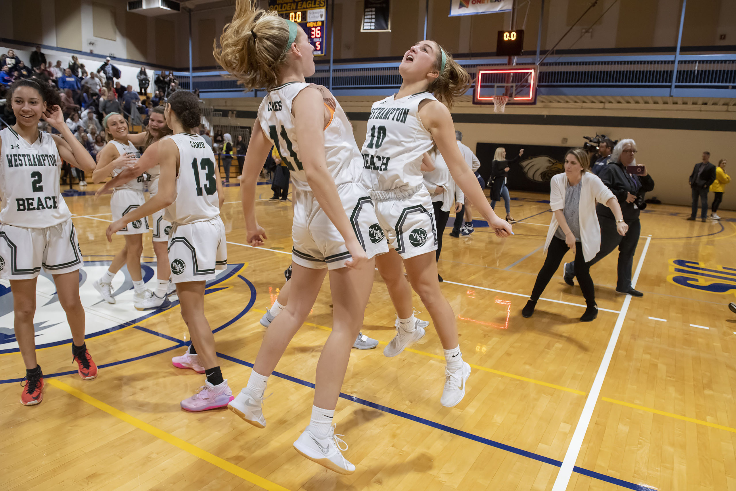 Lady Hurricanes Molly Skorobohaty, left, and Caroline Henke share a chest bump as the final buzzer goes off and marks the end of the county championship game. Westhampton Beach defeated West Babylon, 38-36, at St. Joseph's College in Patchogue on Tuesday night to win its first county title since the 2004-2005 season.  MICHAEL HELLER