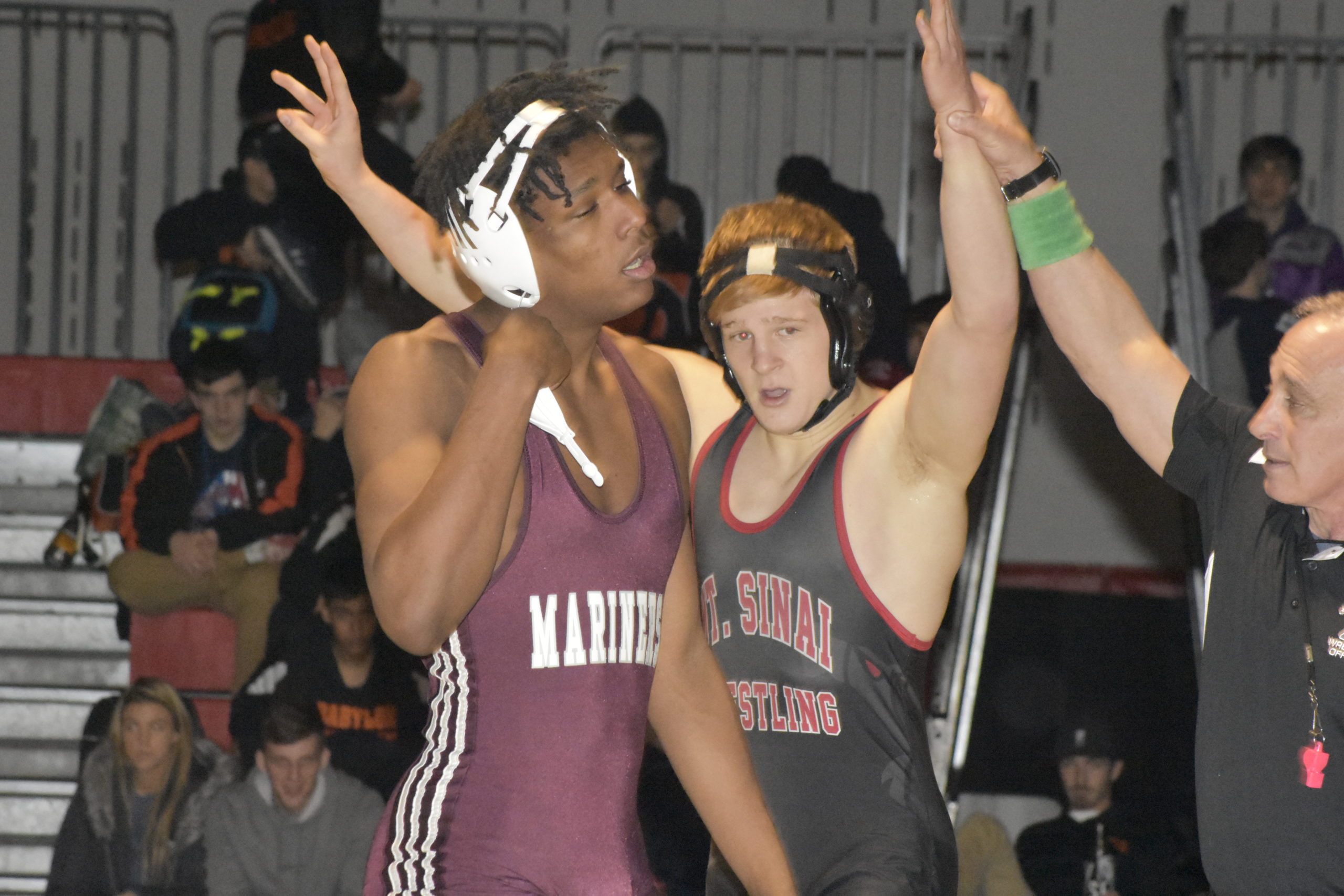 Mount Sinai's Matt Campo gets his hands raised as county champion while Southampton's Ben Brown walks off the mat.