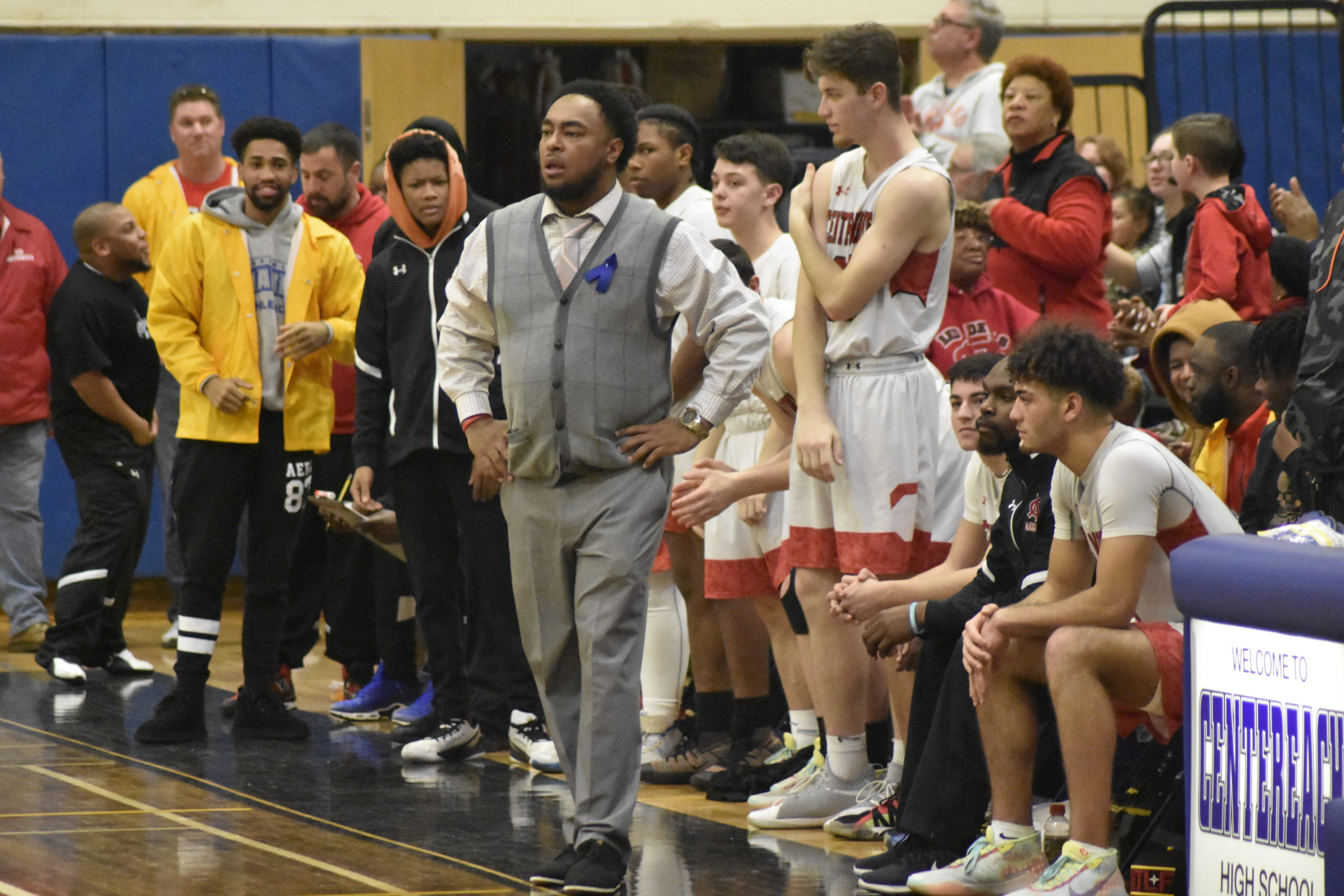 Center Moriches head coach Nick Thomas with his players behind ready to celebrate their fourth consecutive county title.