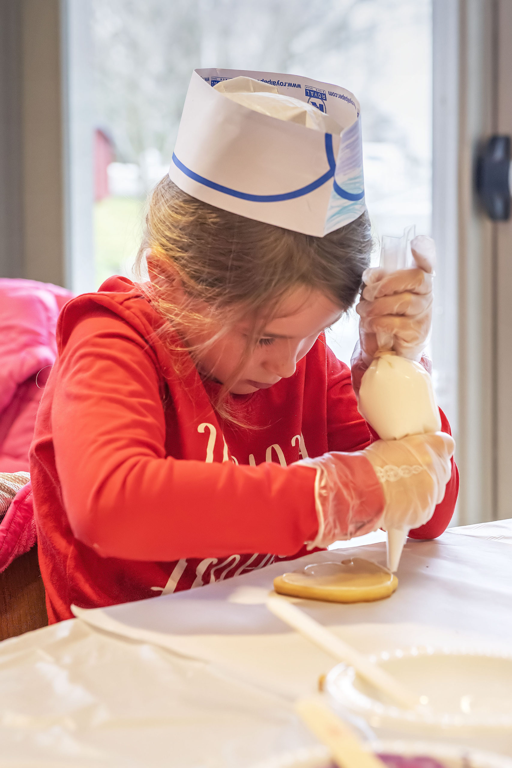 Seven-year-old Abigayle Leland is a study in concentration as she applies some icing during a Football Jersey Cookie Decorating Workshop that was held at the John Jermain Library on Saturday.   MICHAEL HELLER